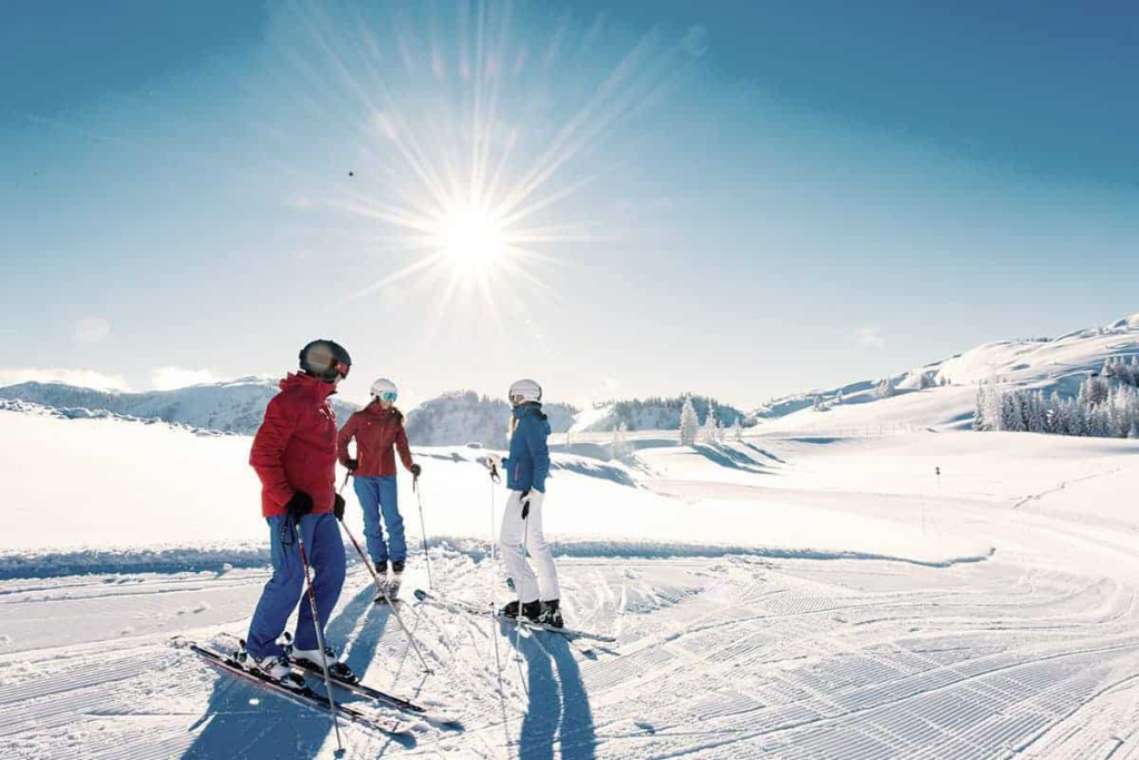 Skifahrer in der Sonne auf verschneiter Piste im Hochkönig-Gebiet. Ideal für Skiurlaub.