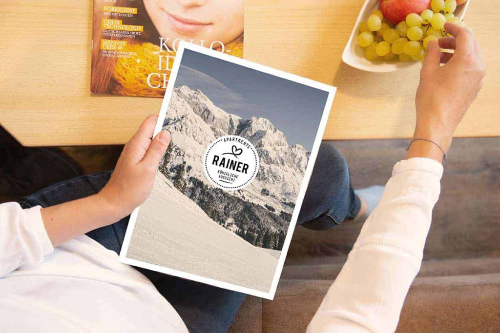 Appartmenthaus Rainer mit Bergblick, Zeitschrift und frischem Obst auf einem Tisch.