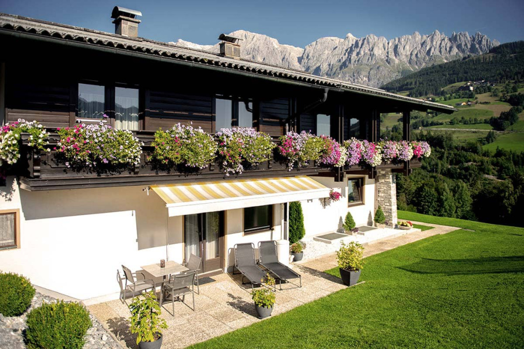 Feriendomizil mit Blumenbalkon und Blick auf die Berge im Salzburger Land. Ideal für aktive Ferien.
