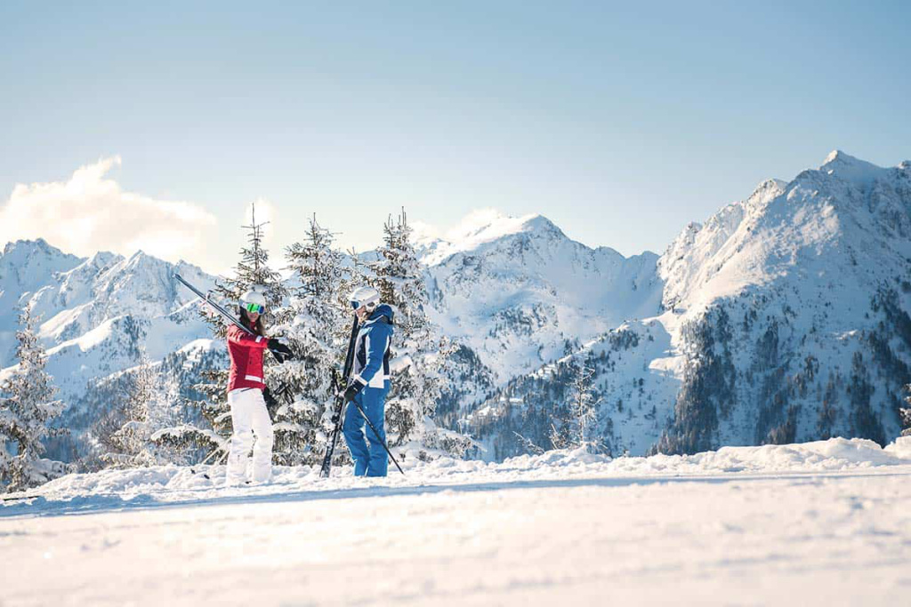 Paar beim Skifahren mit Blick auf die verschneiten Berge im Hochkönig-Gebiet.