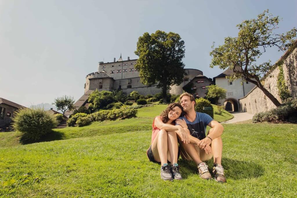 Paar auf einer Wiese vor einer Burg, idyllische Umgebung in Mühlbach am Hochkönig.