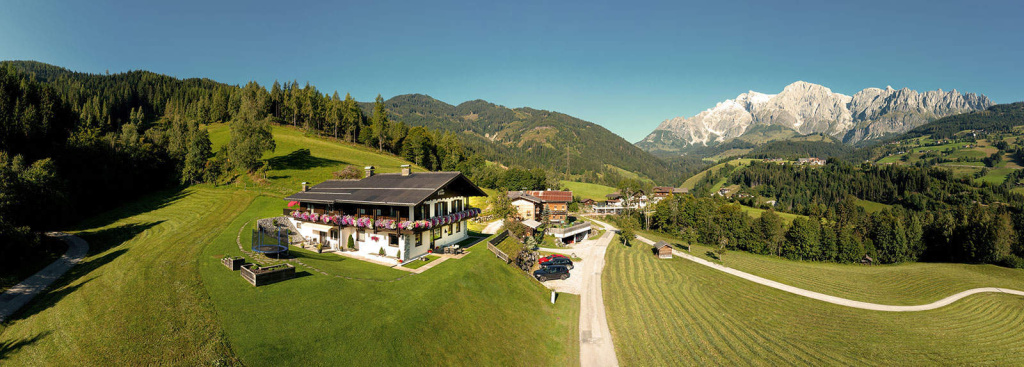 Home Panoramaansicht des Apartmenthauses Rainer mit Hochkönig im Hintergrund, ideal für Urlaub und Erholung.