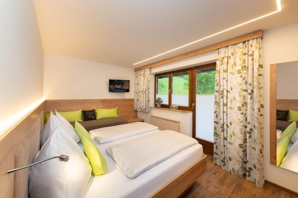 Gemütliches Schlafzimmer im Apartmenthaus Rainer mit Blick ins Grüne.
