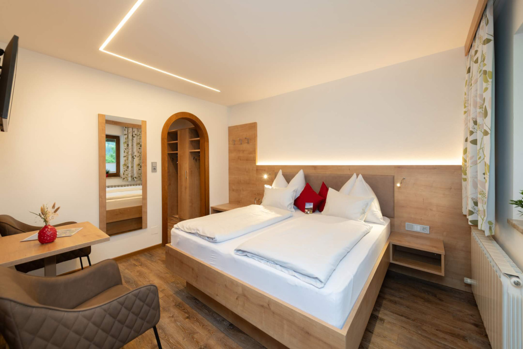 Gemütliches Schlafzimmer im Apartmenthaus Rainer mit Doppelbett und Holzdesign.