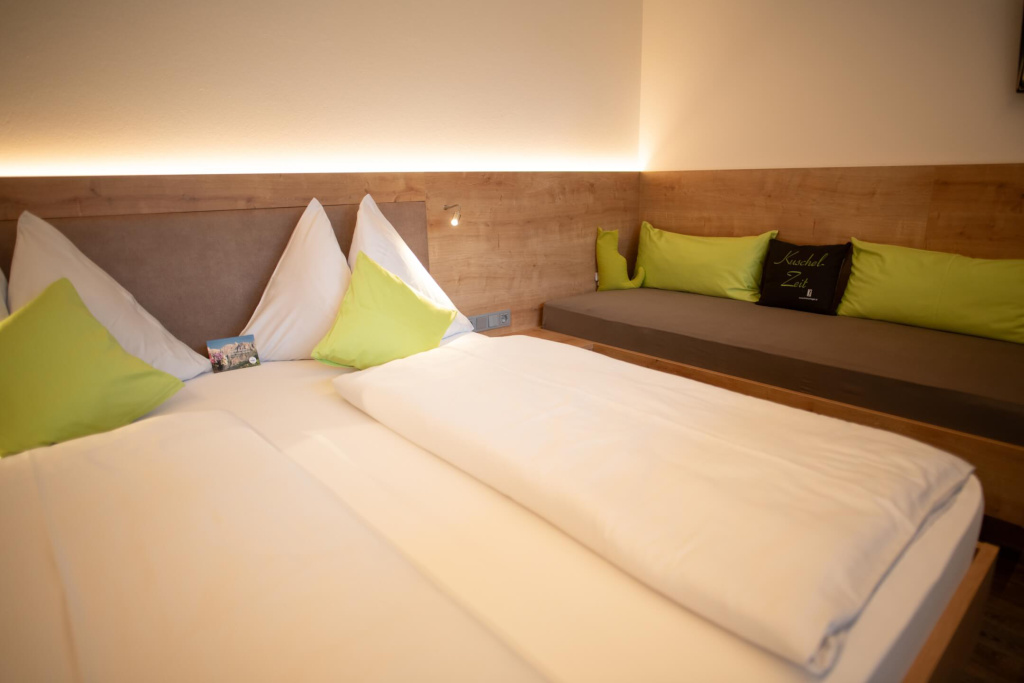 Gemütliches Schlafzimmer im Apartmenthaus Rainer mit Doppelbett und Sitzbereich.